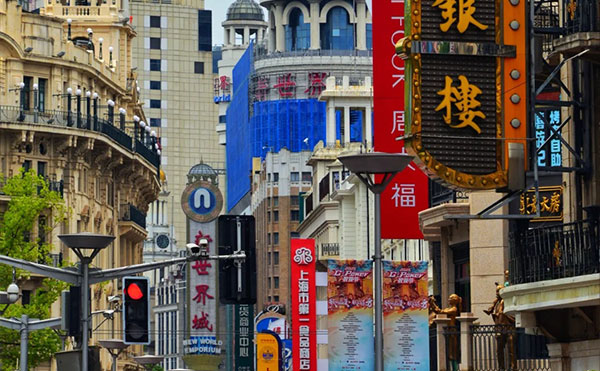 上海南京路步行街白天街景，红色有轨电车和游客人潮